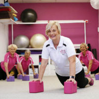 Pilates teacher demonstrating pose with midlife clients